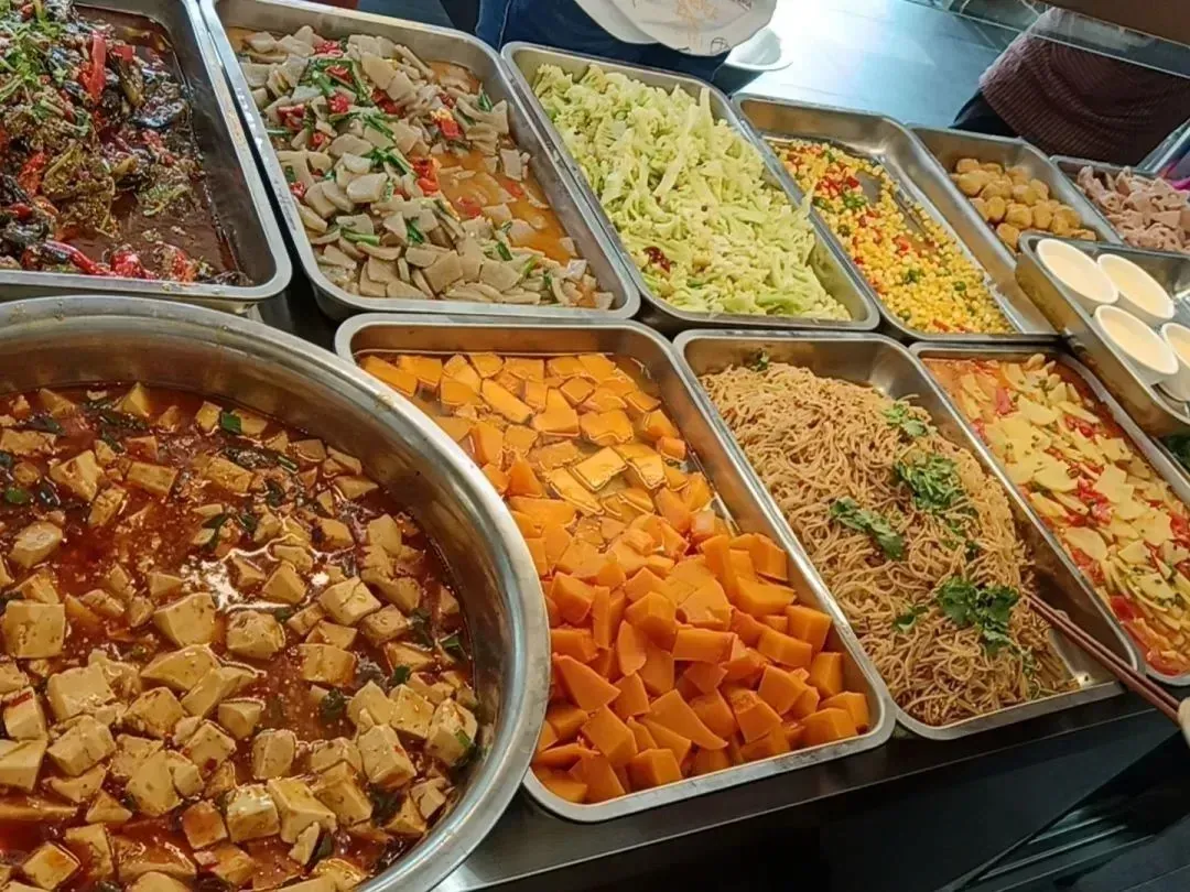 园区食堂的打菜窗口，摆放着多份热菜