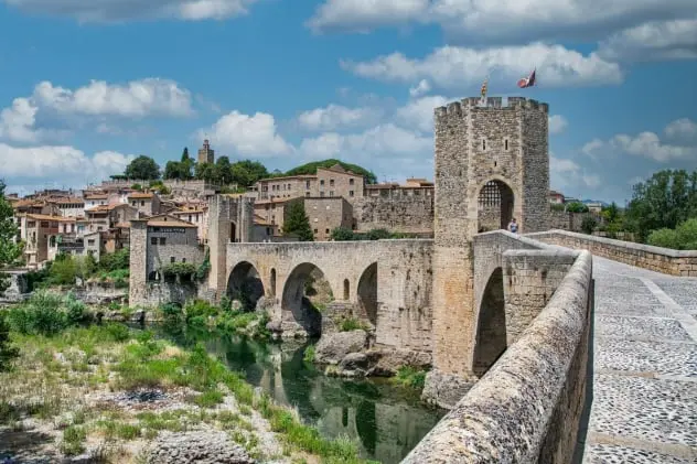 Explora Besalú, uno de los pueblos medievales más encantadores de Cataluña. Su emblemático puente románico sobre el río Fluvià es un tesoro histórico que te transporta al pasado. Pasea por sus calles adoquinadas, descubre su patrimonio judío y disfruta de la belleza arquitectónica en un entorno lleno de historia y tradición. Ideal para turismo cultural.