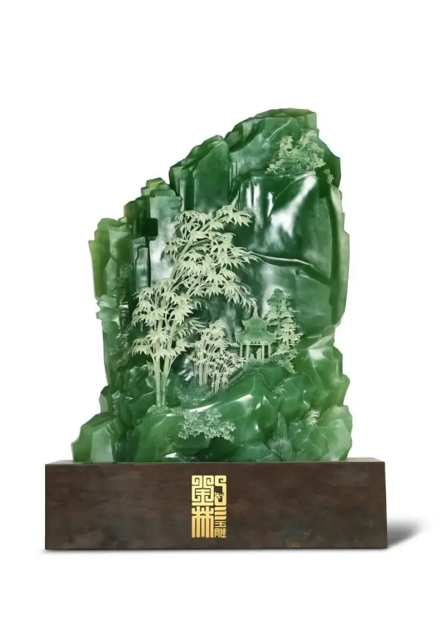 Escultura de jade tallada a mano que representa un paisaje natural con bambúes y montañas. Esta obra de arte combina la elegancia del jade verde con la precisión artesanal, simbolizando prosperidad y tranquilidad. Ideal para coleccionistas y decoración de interiores, aportando un toque cultural y sofisticado. Un ejemplo único del arte tradicional chino en piedra preciosa.