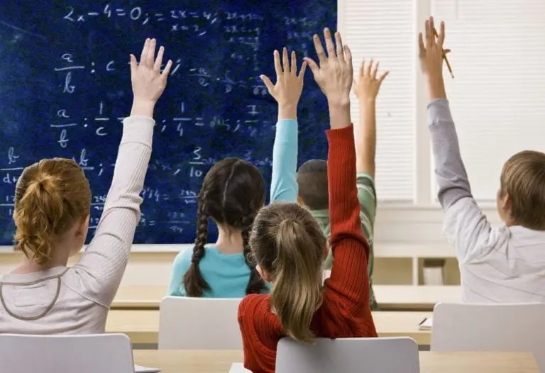 Clase interactiva donde estudiantes levantan la mano para participar activamente en la resolución de problemas matemáticos en la pizarra. Un ambiente educativo dinámico que fomenta el pensamiento crítico, la colaboración y el aprendizaje activo. Ideal para potenciar habilidades analíticas y participación en el aula. Refleja el compromiso con la educación de calidad y el desarrollo académico de los alumnos.