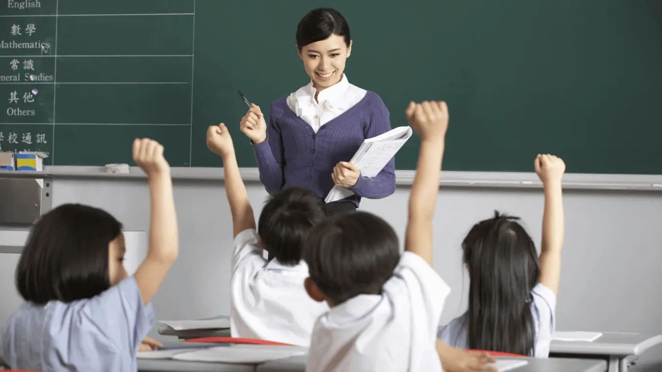 Clase interactiva en una escuela donde una profesora guía a niños participativos con entusiasmo. Ambiente educativo dinámico enfocado en el aprendizaje activo y el desarrollo integral. Ideal para resaltar la importancia de la educación de calidad y el compromiso docente. Refleja valores de colaboración, respeto y crecimiento personal en el aula.