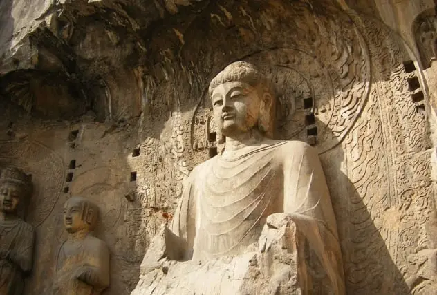 La imagen muestra las impresionantes grutas de Longmen, en China, un conjunto de esculturas budistas talladas en piedra que datan de las dinastías Wei y Tang. Este sitio, declarado Patrimonio de la Humanidad por la UNESCO, destaca por su arte milenario y su profundo significado espiritual. Las grutas de Longmen son un destino imprescindible para amantes de la historia y la cultura.